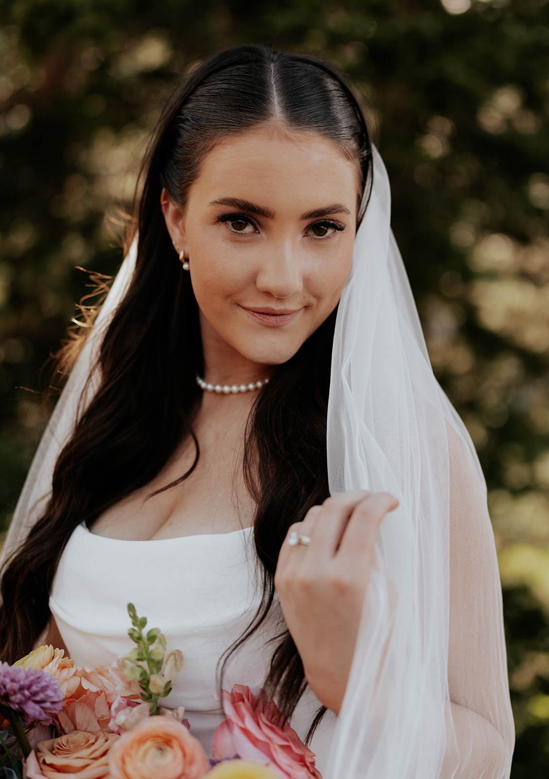 a portrait of a bride holding her veil