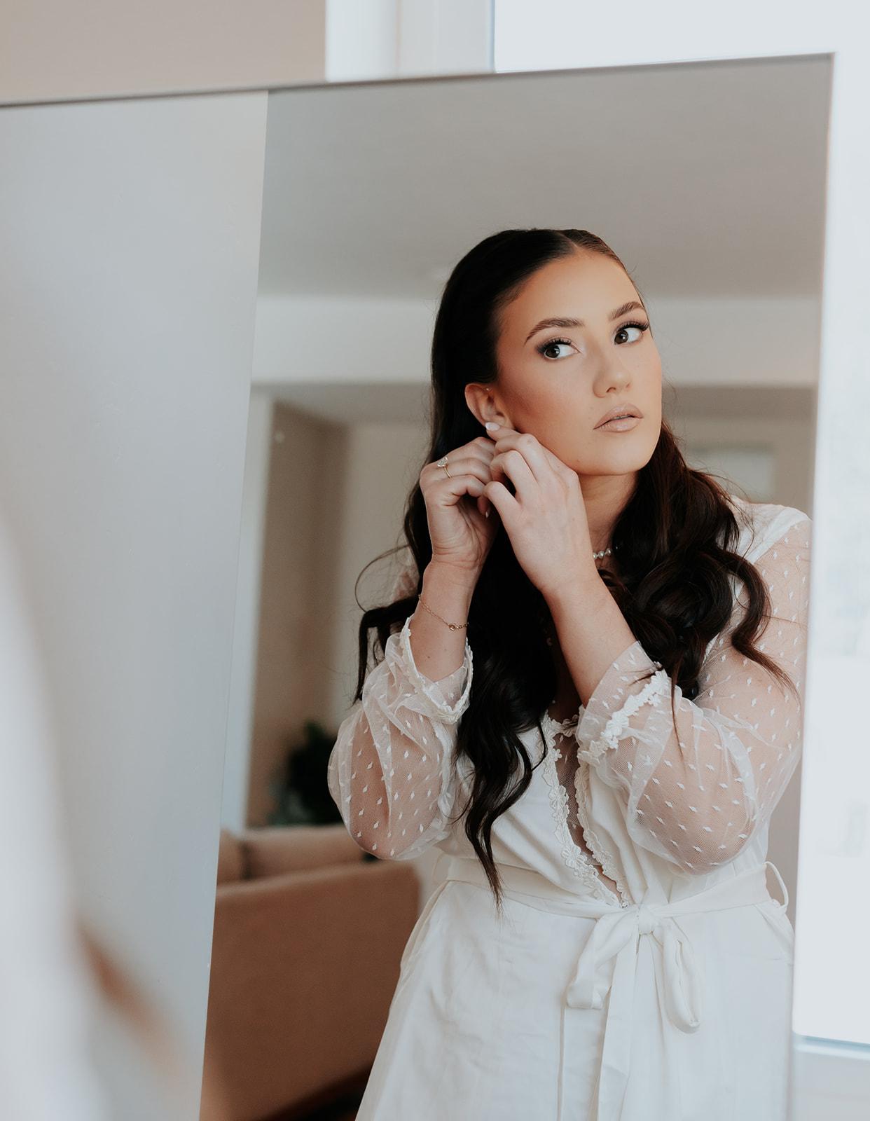 bride putting in earrings to prepare for her ski resort wedding