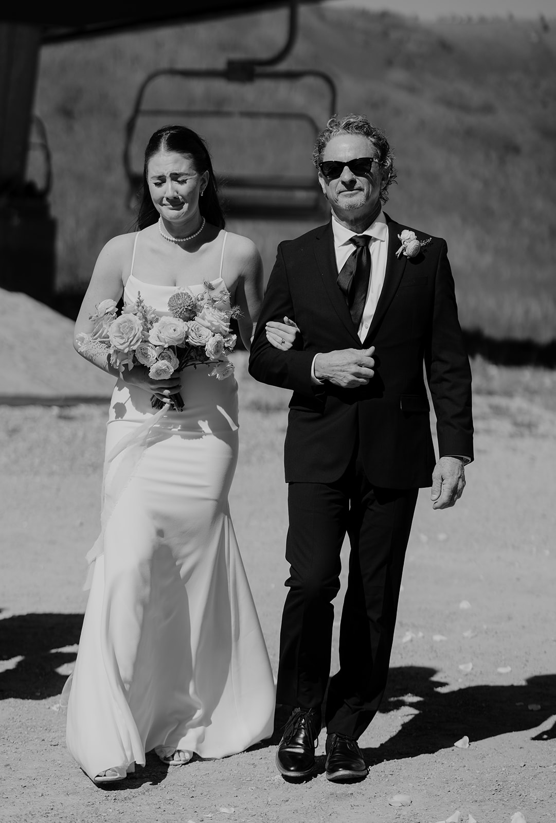 a bride crying while walking down the aisle at her ski resort wedding